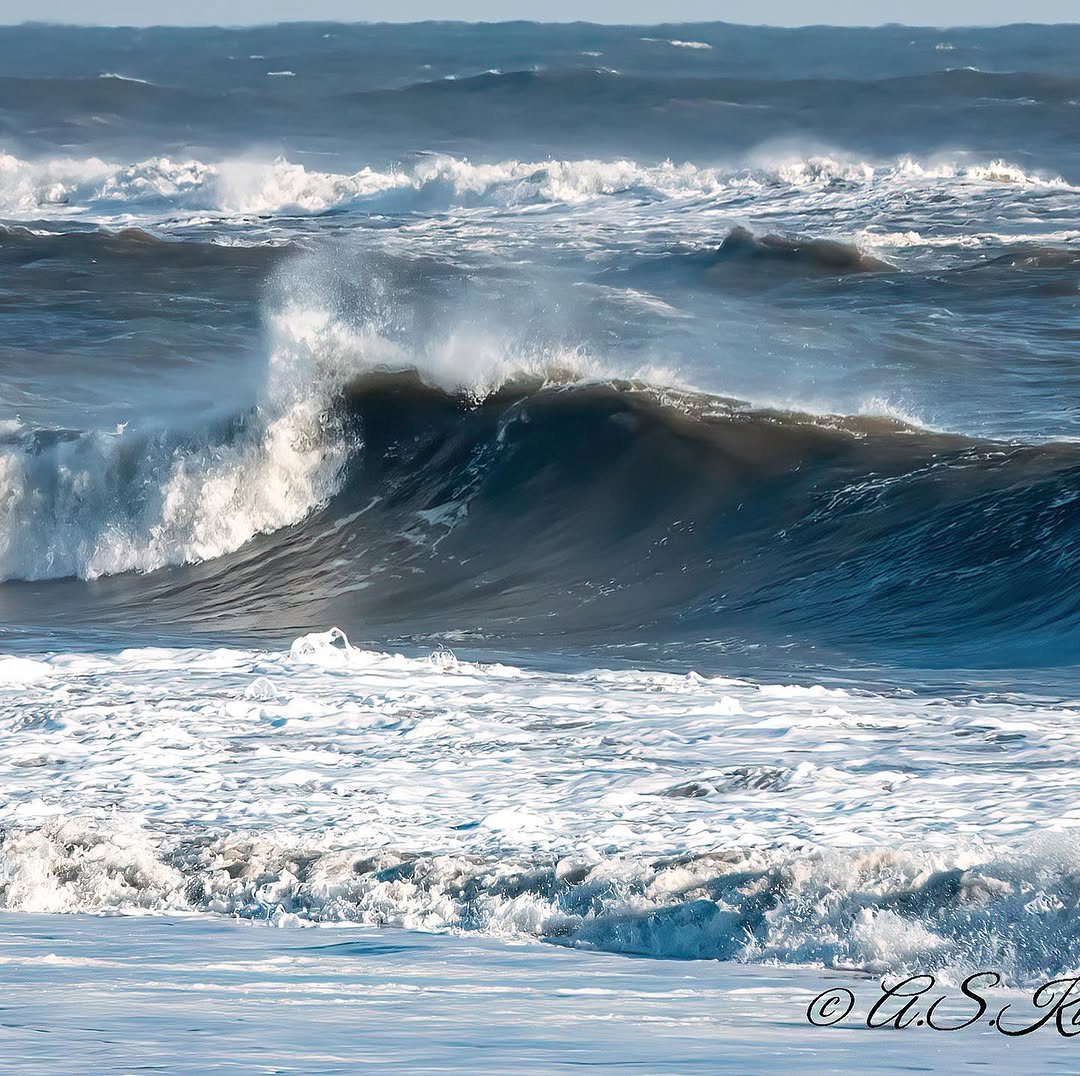 Deep teal wave curling in a winter sea